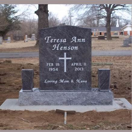 A polished gray granite headstone engraved with the name "Teresa Ann Henson," birth and death dates, and a cross design, accompanied by two matching granite vases on a solid base.